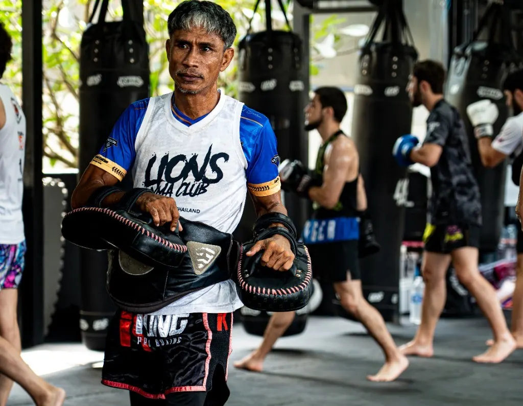 Muay Thai coach holding pads at Lions MMA Club Phuket